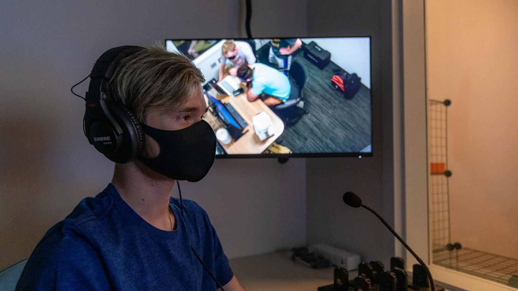 a short-haired man sitting with a headset on